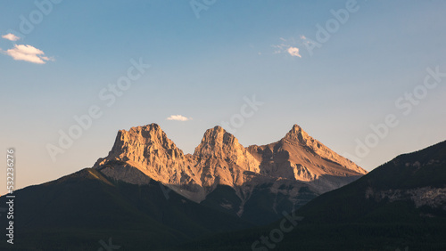 Sun shining on Three Sisters Mountains in Banff National Park, Canada. photo