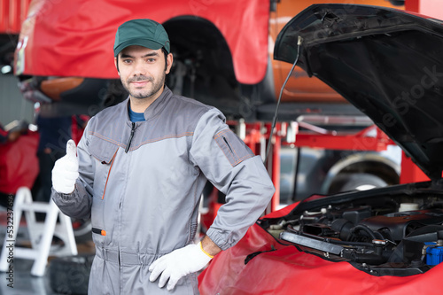 car service, repair, maintenance concept - Arab auto mechanic man or Smith stand beside a car at workshop warehouse before start checking a car in the garage for maintenance services