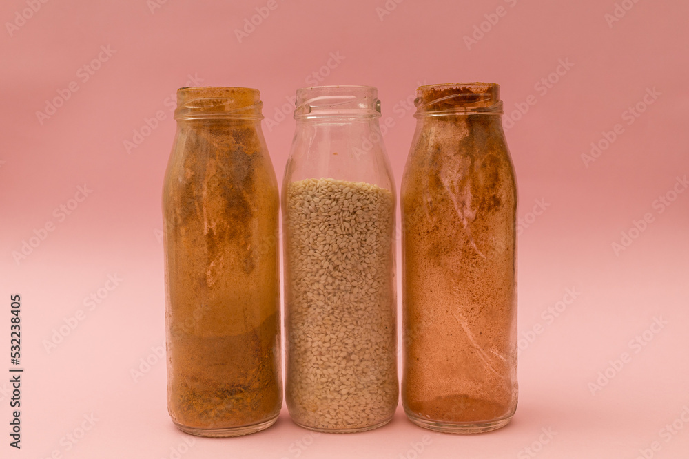 Spices in glass jars on a pink background Spices in glass jars on a pink background