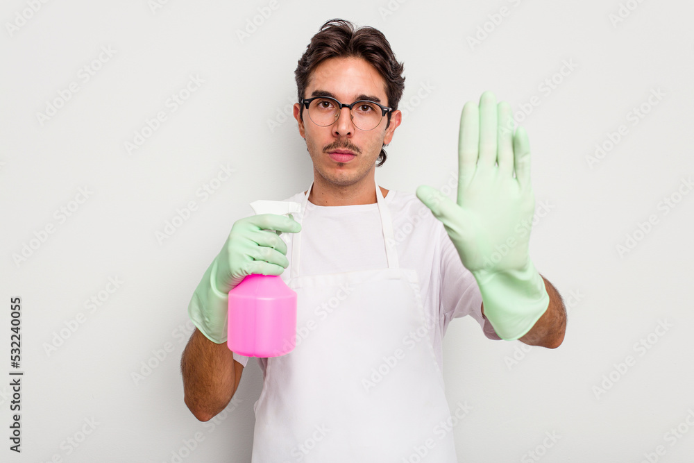 Young cleaner hispanic man isolated on white background standing with outstretched hand showing stop sign, preventing you. Young cleaner hispanic man isolated on white background standing with outstretched hand showing stop sign, preventing you.