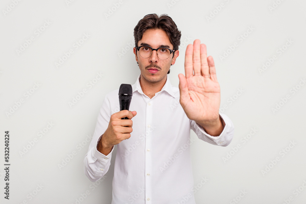 Young hispanic singer man isolated on white background standing with outstretched hand showing stop sign, preventing you. Young hispanic singer man isolated on white background standing with outstretched hand showing stop sign, preventing you.