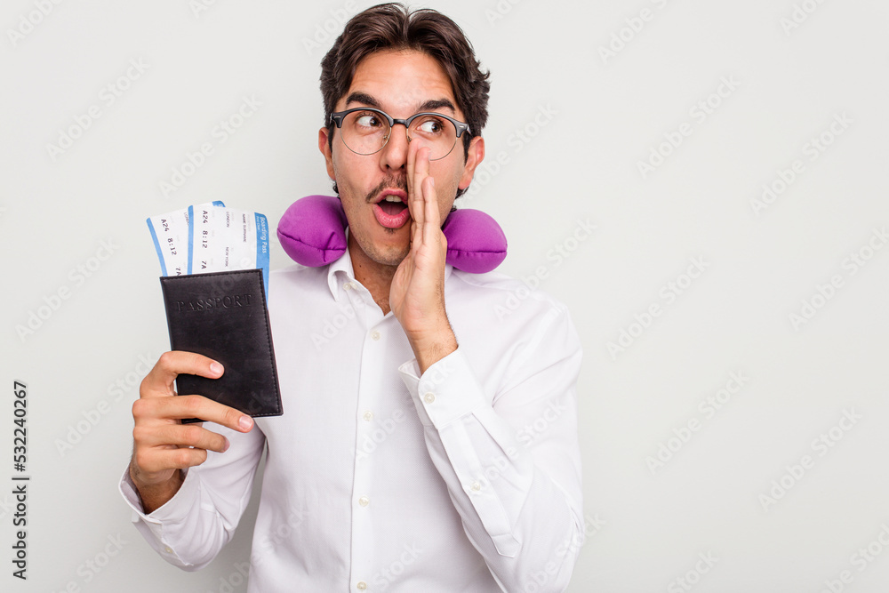 Young hispanic man with inflatable travel pillow holding passport isolated on white background is saying a secret hot braking news and looking aside Young hispanic man with inflatable travel pillow holding passport isolated on white background is saying a secret hot braking news and looking aside