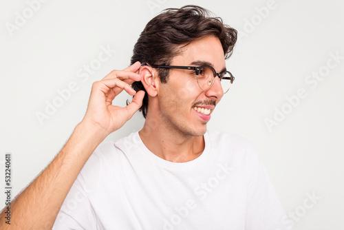 Young hispanic man wearing hearing aid isolated on white background