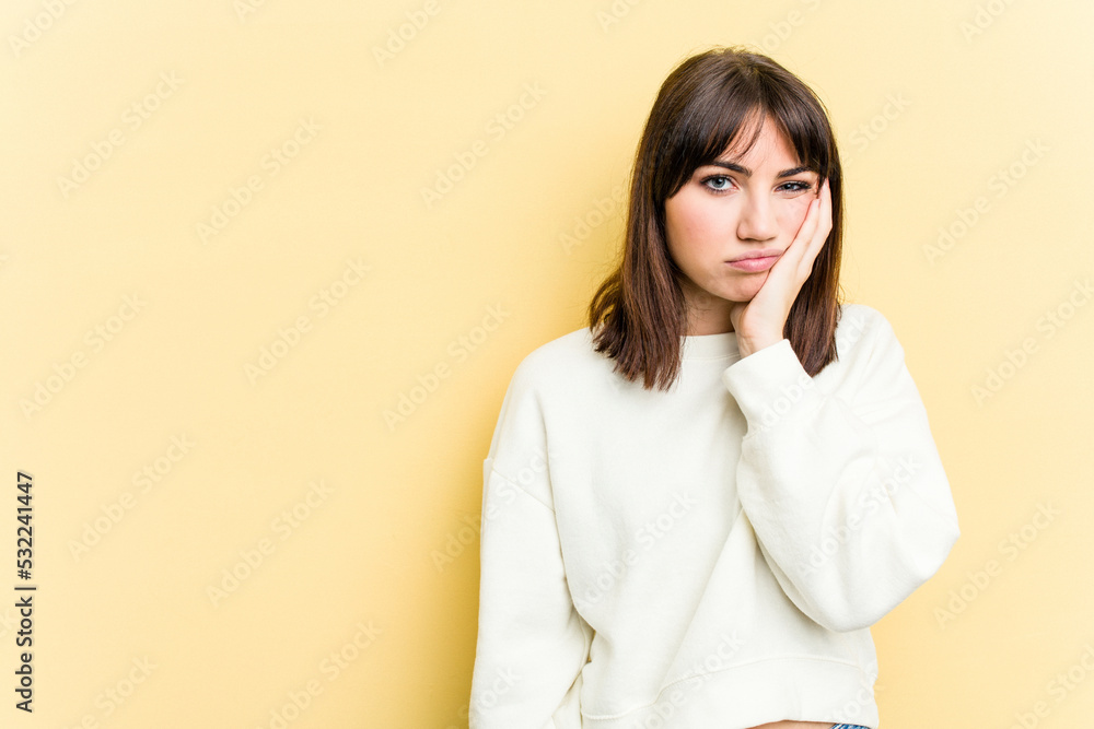 Young caucasian woman isolated on yellow background who feels sad and pensive, looking at copy space. Young caucasian woman isolated on yellow background who feels sad and pensive, looking at copy space.