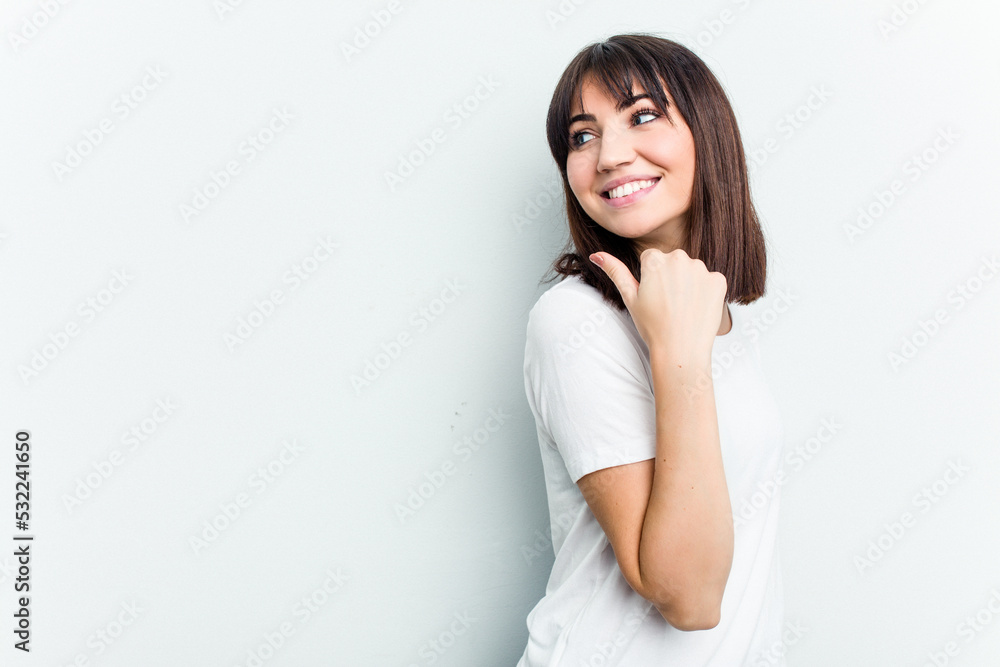 Young caucasian woman isolated on white background points with thumb finger away, laughing and carefree. Young caucasian woman isolated on white background points with thumb finger away, laughing and carefree.