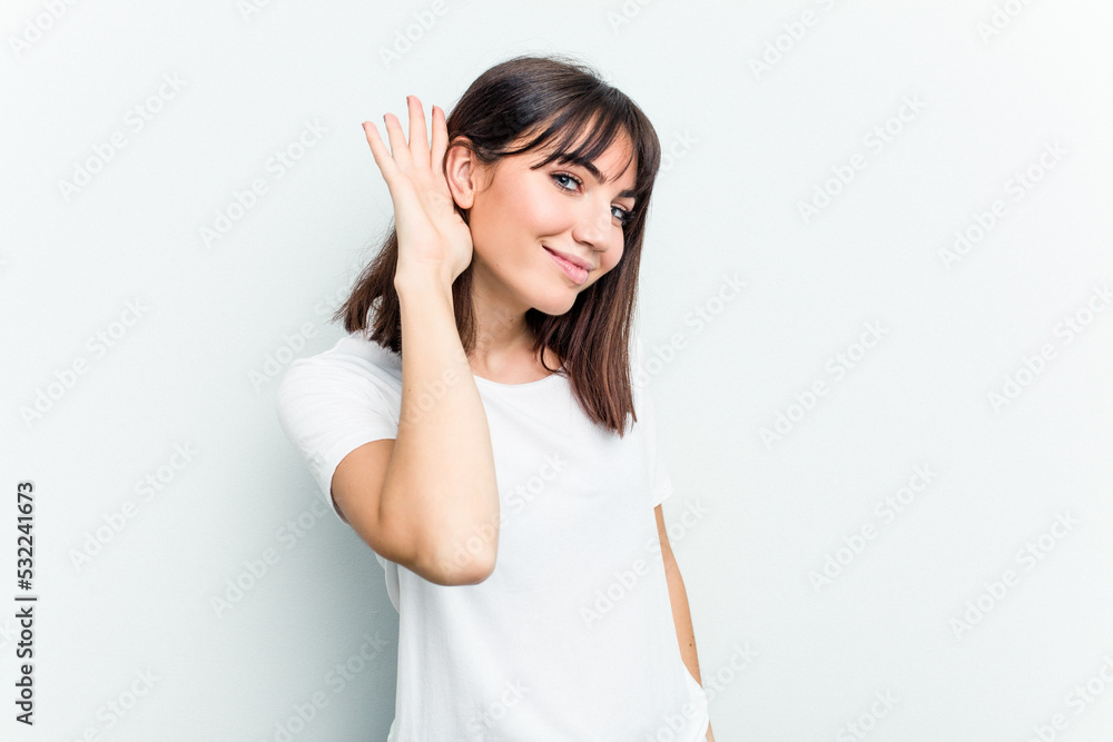 Young caucasian woman isolated on white background trying to listening a gossip. Young caucasian woman isolated on white background trying to listening a gossip.