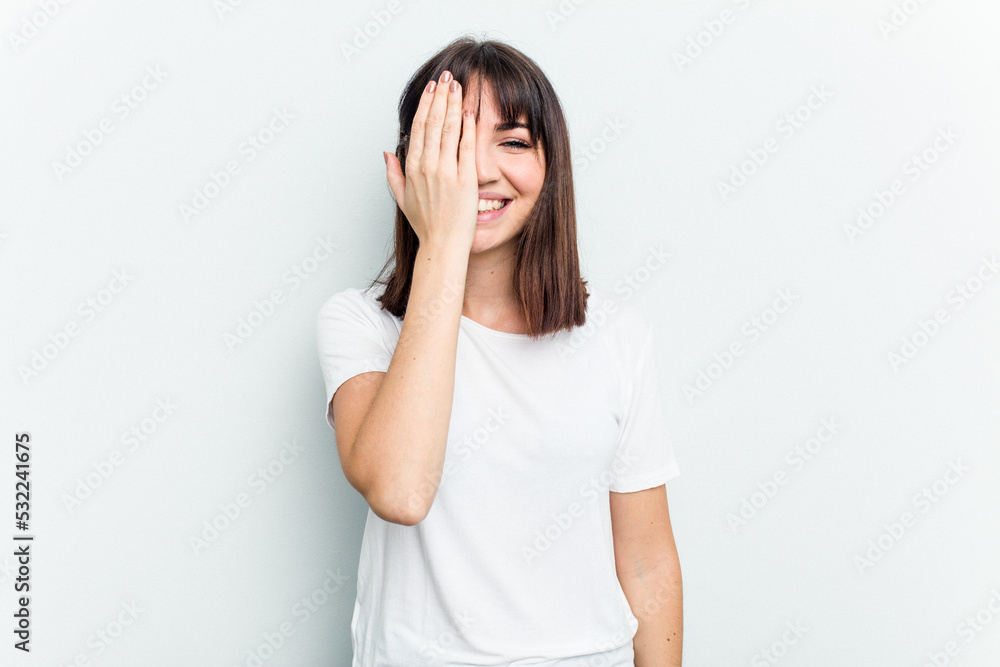 Young caucasian woman isolated on white background having fun covering half of face with palm. Young caucasian woman isolated on white background having fun covering half of face with palm.