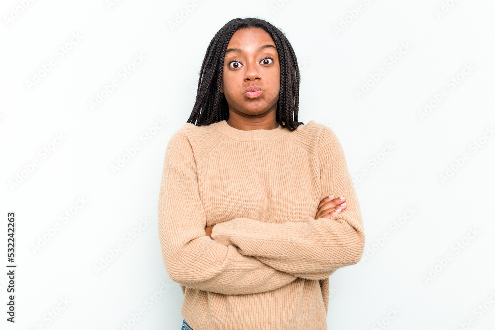 Young African American woman isolated on white background blows cheeks, has tired expression. Facial expression concept. Young African American woman isolated on white background blows cheeks, has tired expression. Facial expression concept.