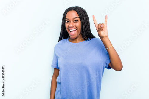 Print op canvas Young African American woman with braids hair isolated on blue background showing a horns gesture as a revolution concept