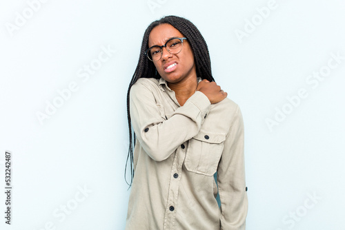 Young African American woman with braids hair isolated on blue background having a shoulder pain. © Asier