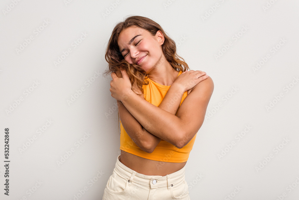 Young caucasian woman isolated on blue background hugs, smiling carefree and happy. Young caucasian woman isolated on blue background hugs, smiling carefree and happy.
