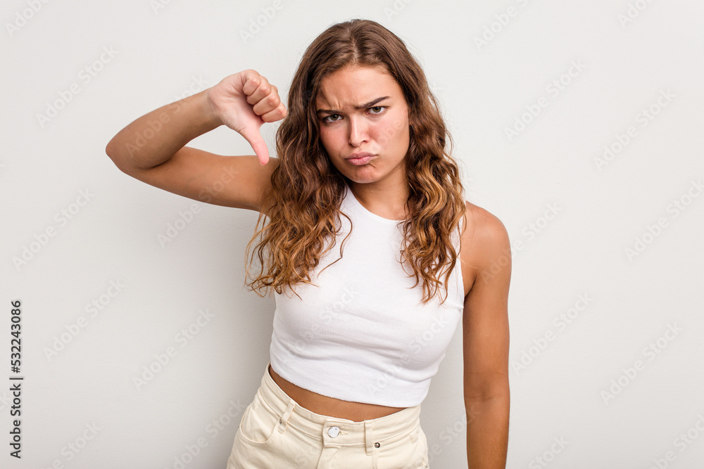 Young caucasian woman isolated on blue background showing thumb down and expressing dislike.