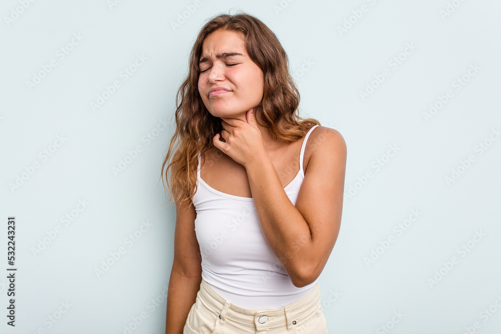 Young caucasian woman isolated on blue background suffers pain in throat due a virus or infection. Young caucasian woman isolated on blue background suffers pain in throat due a virus or infection.