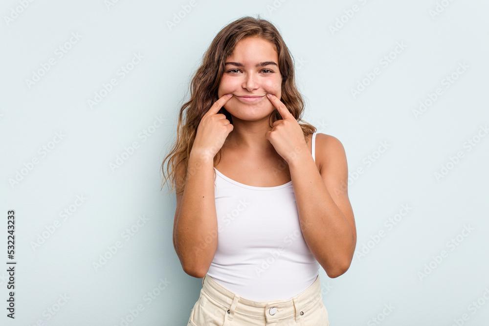 Young caucasian woman isolated on blue background doubting between two options. Young caucasian woman isolated on blue background doubting between two options.