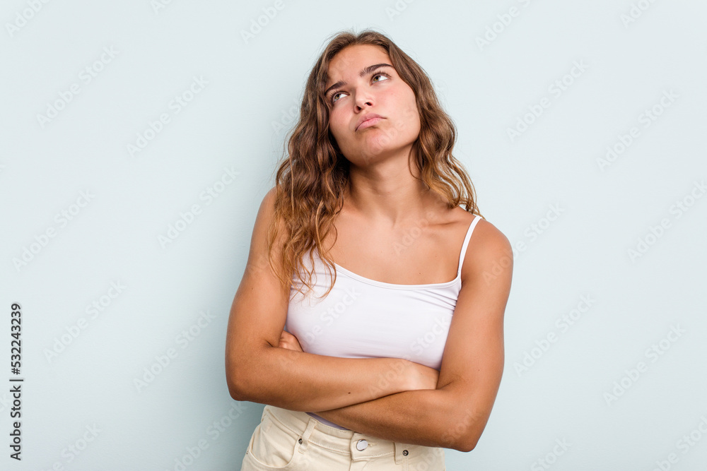Young caucasian woman isolated on blue background tired of a repetitive task. Young caucasian woman isolated on blue background tired of a repetitive task.