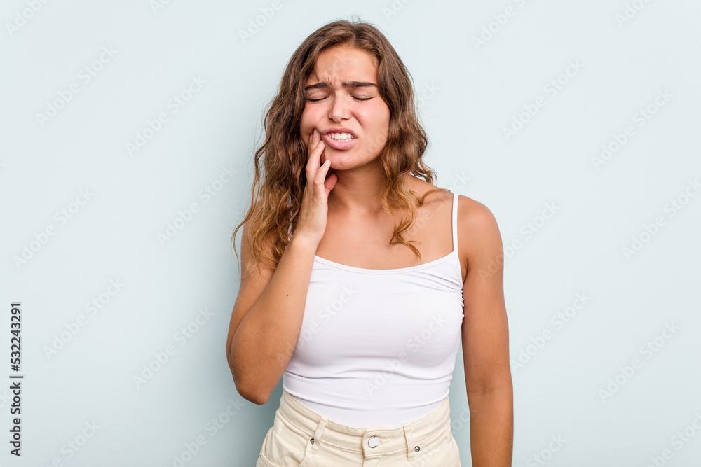 Young caucasian woman isolated on blue background having a strong teeth pain, molar ache. Young caucasian woman isolated on blue background having a strong teeth pain, molar ache.