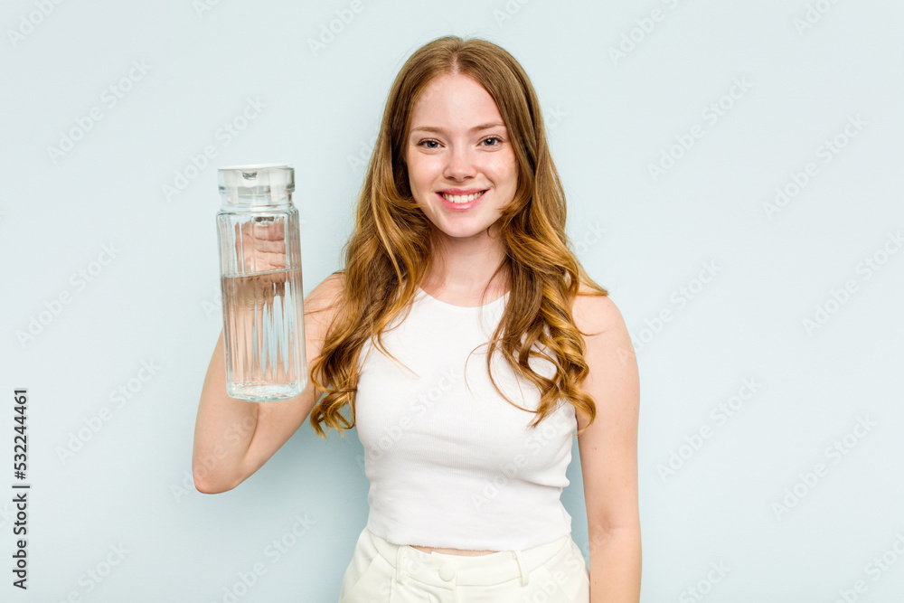 Young caucasian woman holding jar of water isolated on blue background happy, smiling and cheerful. Young caucasian woman holding jar of water isolated on blue background happy, smiling and cheerful.