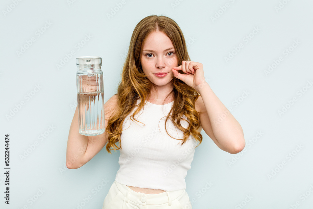 Young caucasian woman holding jar of water isolated on blue background with fingers on lips keeping a secret. Young caucasian woman holding jar of water isolated on blue background with fingers on lips keeping a secret.