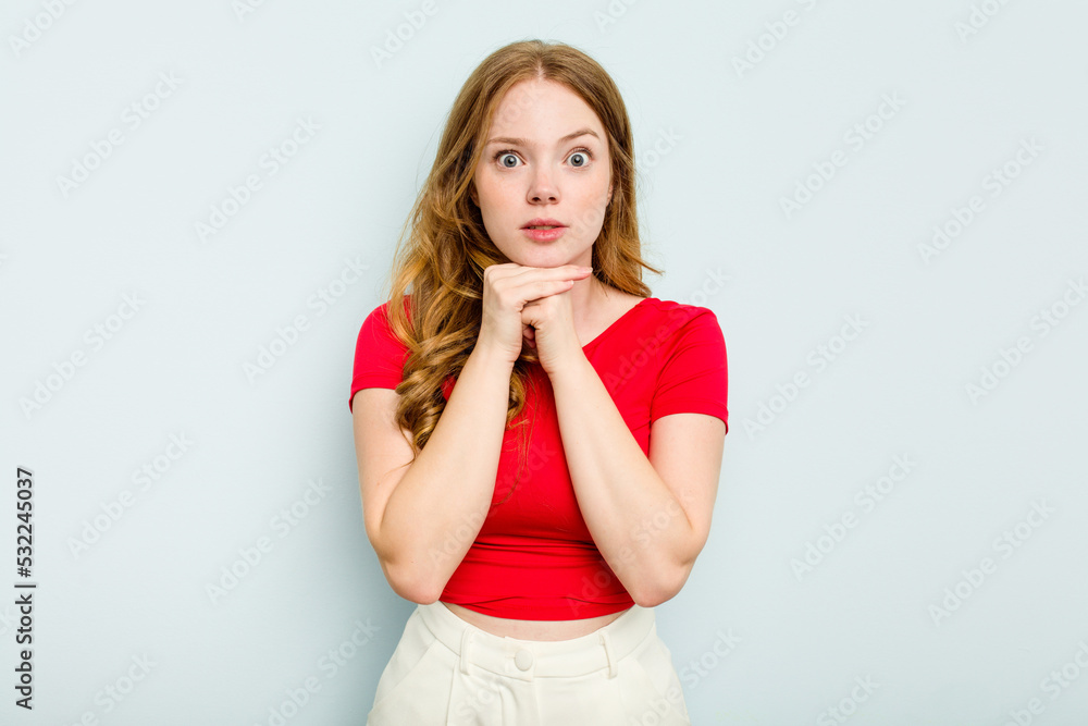 Young caucasian woman isolated on blue background praying for luck, amazed and opening mouth looking to front. Young caucasian woman isolated on blue background praying for luck, amazed and opening mouth looking to front.