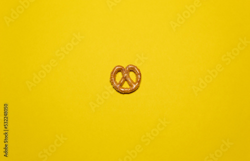 A small pretzel isolated on a yellow background