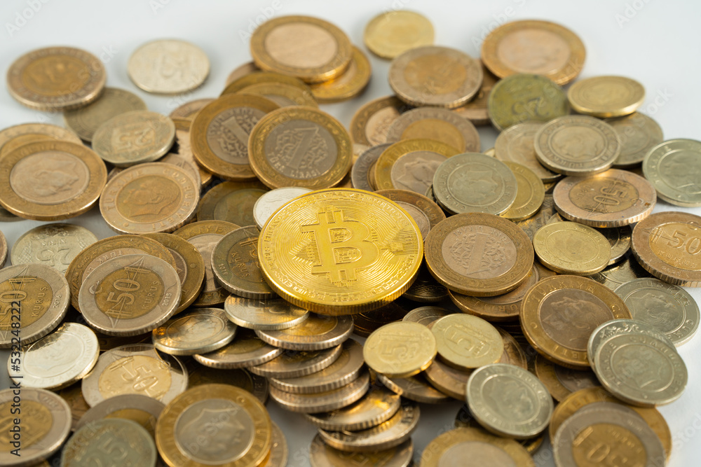 stack of coins and a bitcoin at top stack of coins and a bitcoin at top
