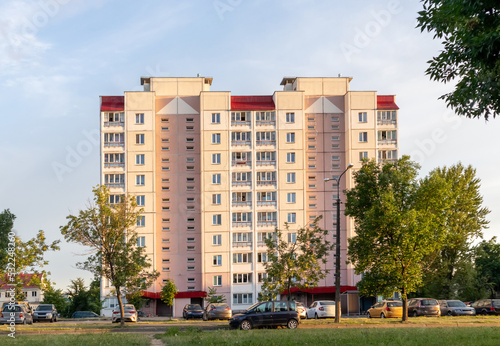 Soviet high-rise building house condominium in cozy town. Street view landscape old city, house on sunset. Soviet architecture street front view. Calm town street. Town street with green trees