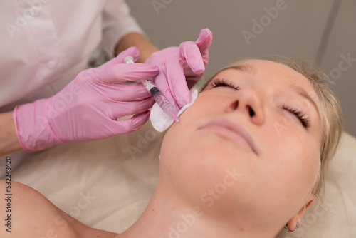 Cosmetologist makes injections on the face. Spa concept relaxation and self-care.
