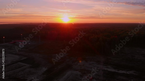 Bright sunset over the horizon in the tundra where oil and gas are extracted. A drone view of the sunrise in Siberia. Sunset over the extraction of fossil fuels in the global economy. Oil production.