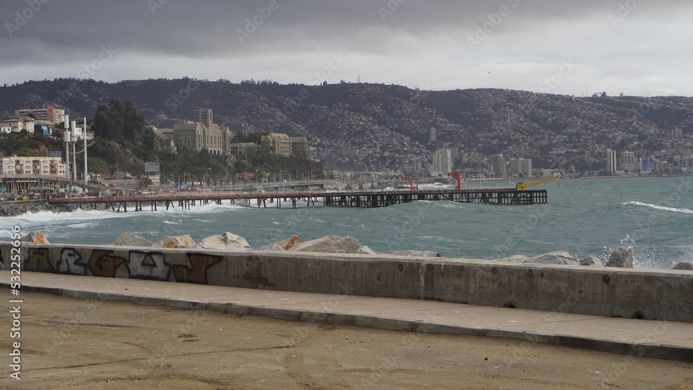 Viste del océano pacifico en Valparaíso, con el muelle de caleta portales de fondo. Se ve el mar agitado por las olas. se avecina una tormenta.