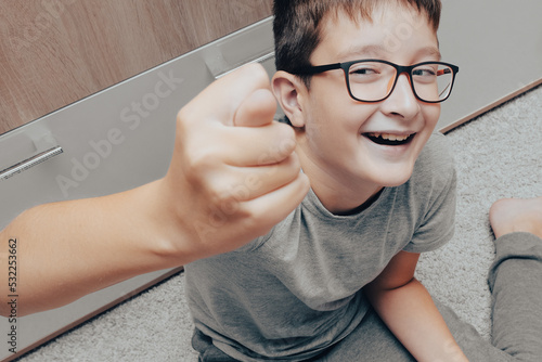 A teenager boy smiling and shiwing fico, fig gesture photo