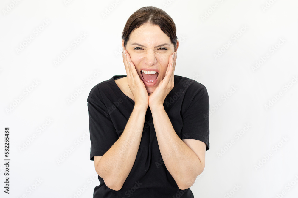 Woman holding her face with hands and screaming. Caucasian woman shouting with open mouth, shocked or surprised. Negative emotion, stress, studio shot, portrait concept Woman holding her face with hands and screaming. Caucasian woman shouting with open mouth, shocked or surprised. Negative emotion, stress, studio shot, portrait concept