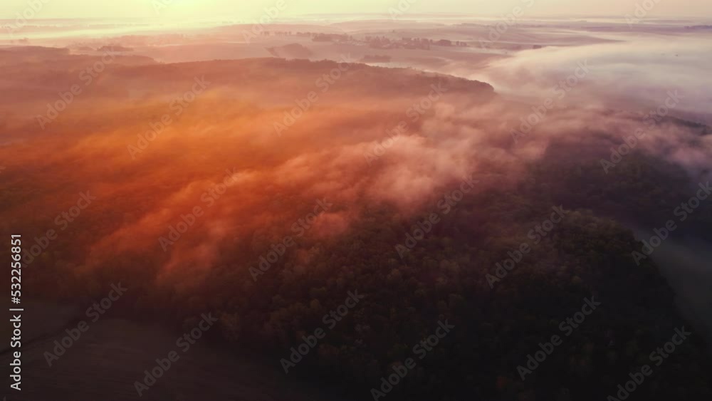 Thick fog spreading over forest and farm fields during colorful sunrise. Orange glare. Landcape of Roztocze Poland. Horizontal shot. High quality 4k footage Thick fog spreading over forest and farm fields during colorful sunrise. Orange glare. Landcape of Roztocze Poland. Horizontal shot. High quality 4k footage