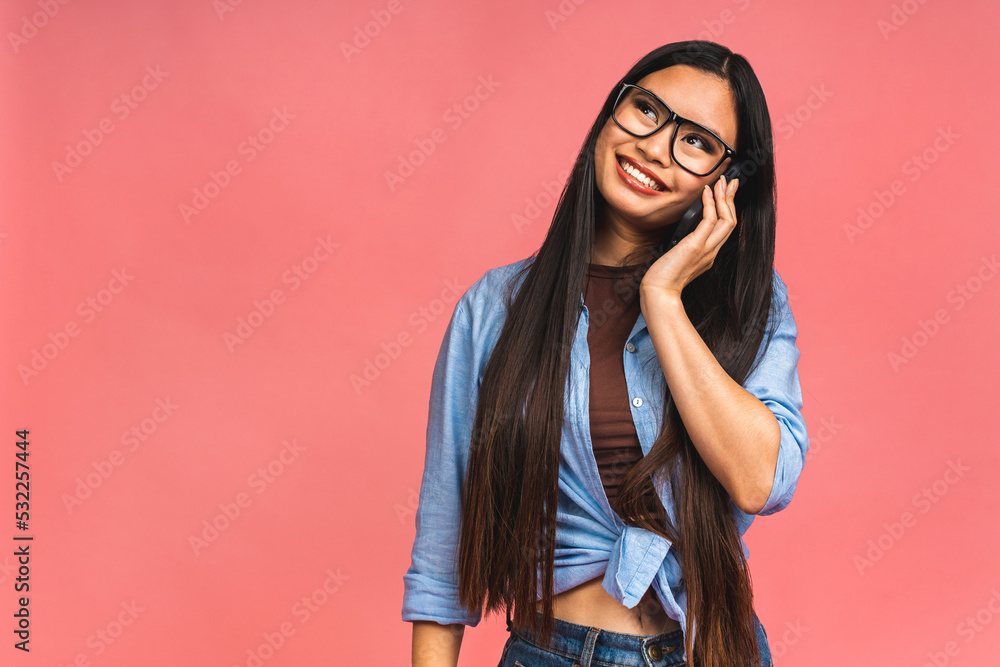 Portrait of a joyful happy smiling Asian businesswoman talking on mobile phone, isolated on pink background. Portrait of a joyful happy smiling Asian businesswoman talking on mobile phone, isolated on pink background.
