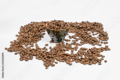 Fototapeta Naklejka Na Ścianę i Meble -  Fragrant roasted coffee beans on a white background and a small cup.