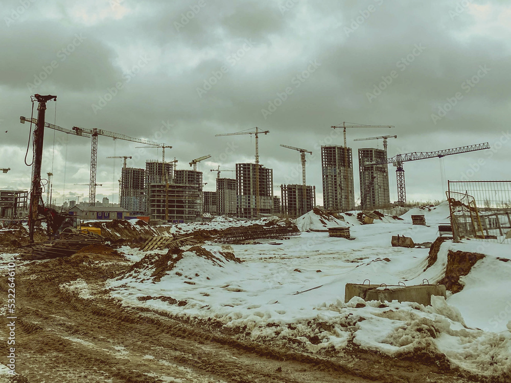 construction of houses, a shopping center from concrete blocks in the city. construction of a new residential quarter in winter. equipment is working on the site, traces of large tires