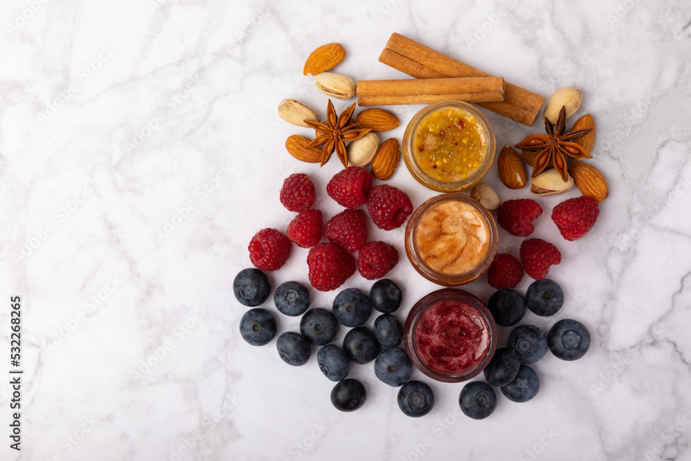 Jar of honey. Fruit honey with raspberries, blueberries, almonds and pistachios. Jams for health and beauty. Honey cream. Organic product of a vegetarian diet. Copy space.Copy space. Jar of honey. Fruit honey with raspberries, blueberries, almonds and pistachios. Jams for health and beauty. Honey cream. Organic product of a vegetarian diet. Copy space.Copy space.