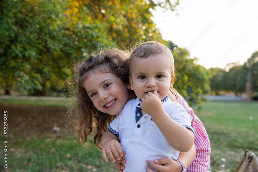 Portrait of brother and sister embracing in a park in the open air, concept of family love. Portrait of brother and sister embracing in a park in the open air, concept of family love.