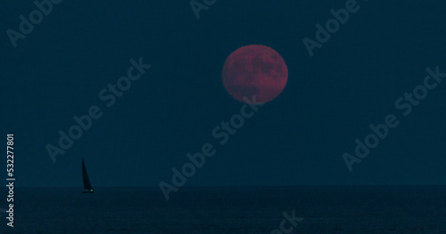 A full moon rising over the sea