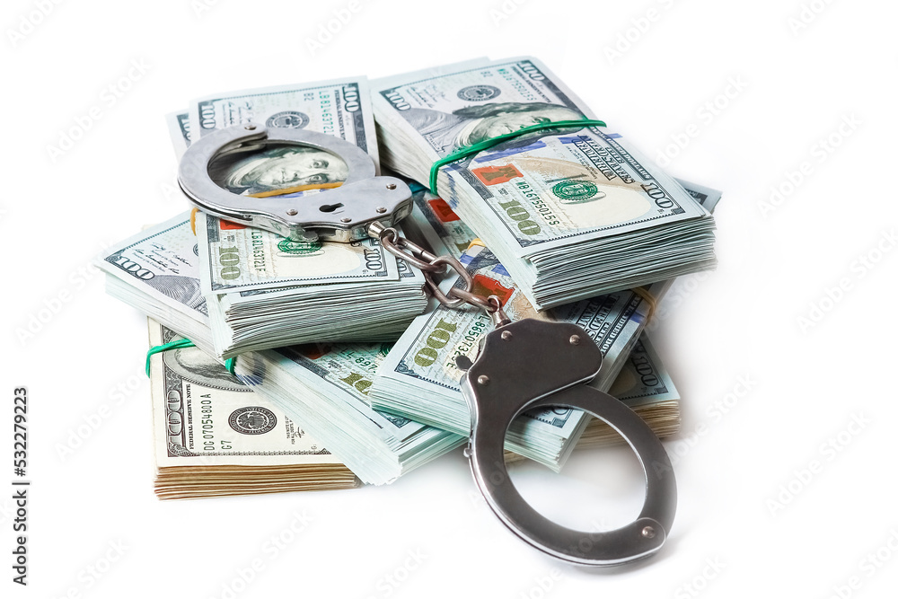 A dollars in bundles on white background with handcuffs crime fraud concept business pandemic A dollars in bundles on white background with handcuffs crime fraud concept business pandemic