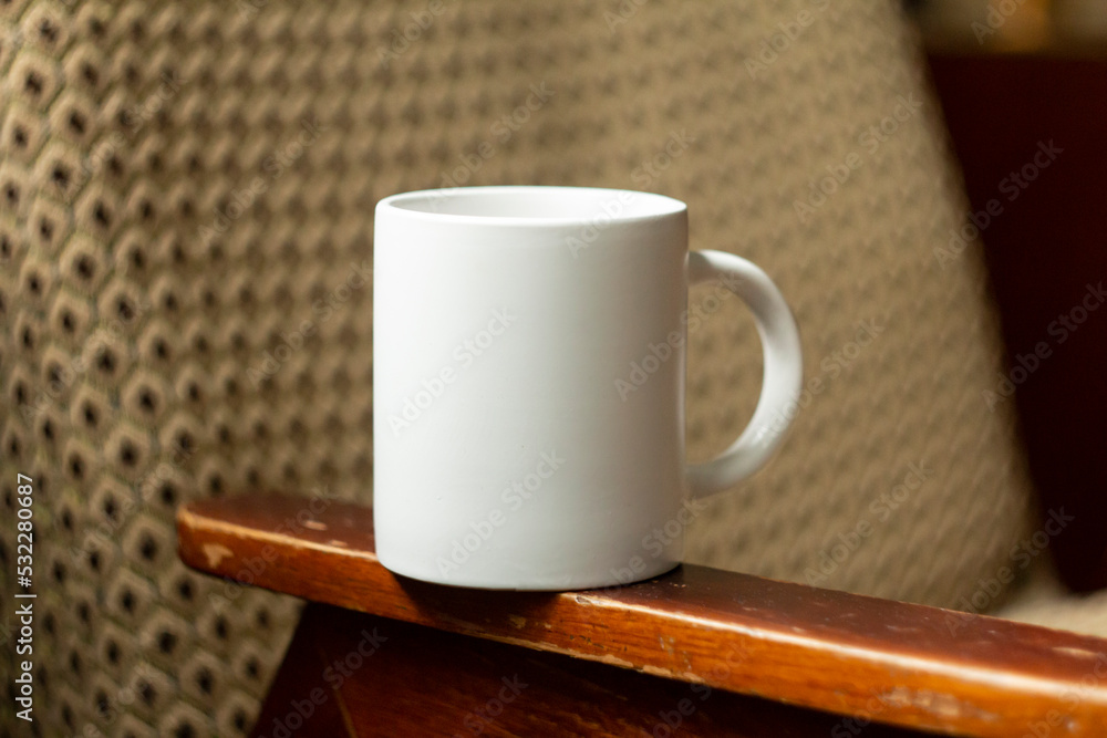 White mug on the armrest of a chair