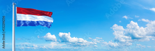 Netherlands flag on a blue sky *** Horizontal banner 12000 x 4005 px