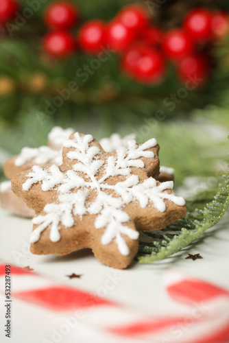 Christmas decoration. Christmas tree branches and homemade decorated Christmas cookies, close up image. 