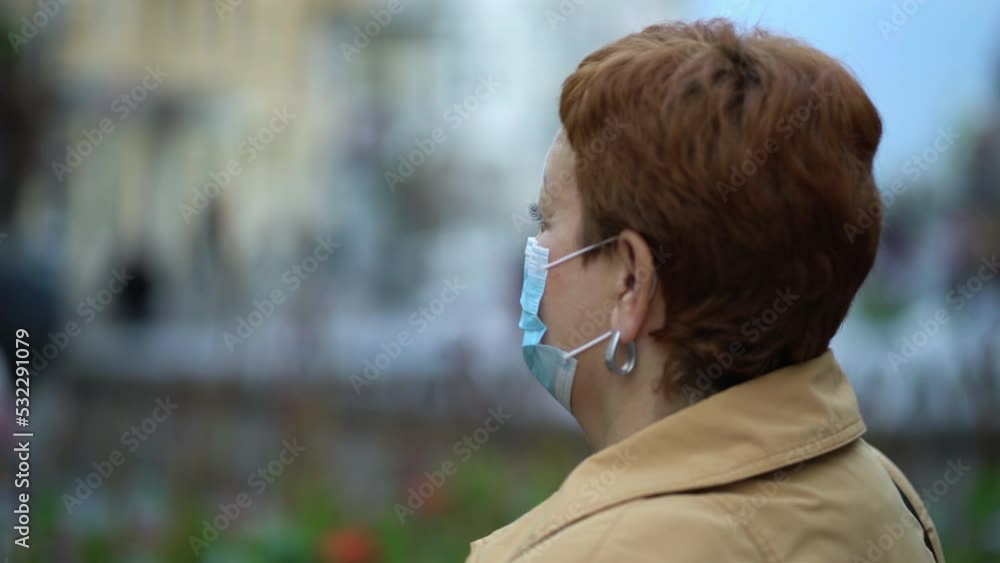 Side view of a woman's hands putting on a protective medical mask against coronavirus in a crowded place in the city. Side view of a woman's hands putting on a protective medical mask against coronavirus in a crowded place in the city.