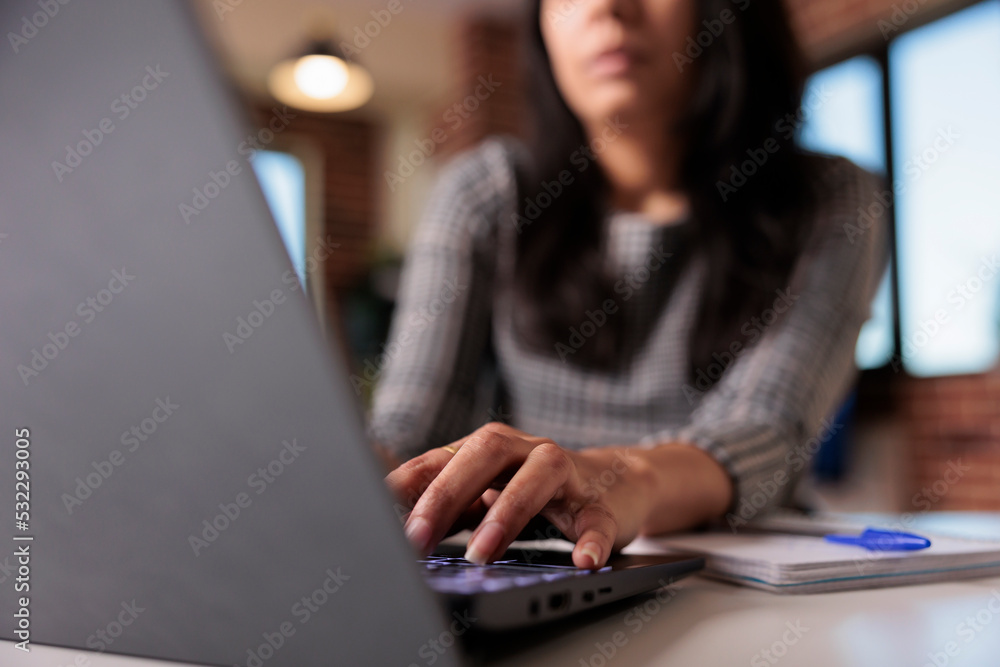 Business woman working on report at home, typing research information on laptop and browsing internet website. Searching data to create professional report and send email. Close up. Business woman working on report at home, typing research information on laptop and browsing internet website. Searching data to create professional report and send email. Close up.