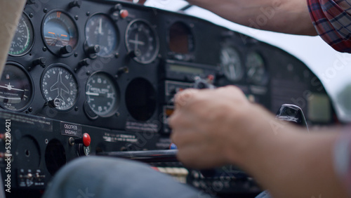 Slika na platnu Hand airman driving airplane checking indicators control panel close up