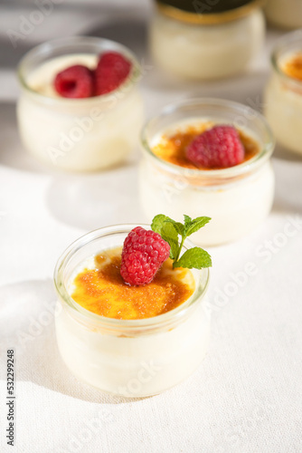 French dessert custard creme brulee with caramel crust  garnished with fresh berries. Traditional cuisine. Vertical photo