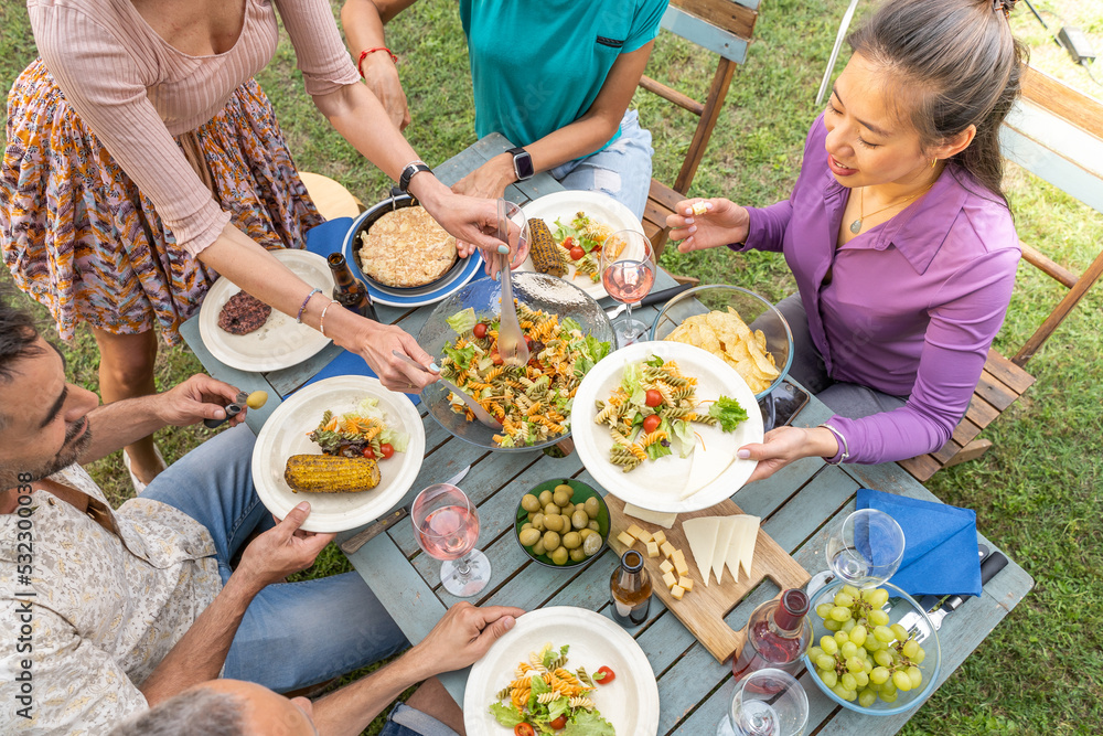 Top view of people serving food and drinks in a wooden teal table. Getting together concept. Top view of people serving food and drinks in a wooden teal table. Getting together concept.