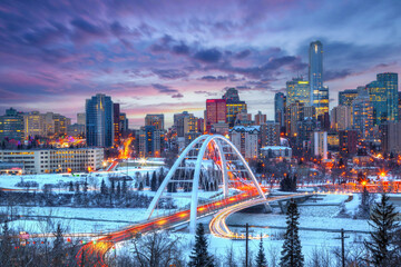 Light trails from rush hour traffic light up Walterdale Bridge in Edmonton, Canada, on a sunset winter night.