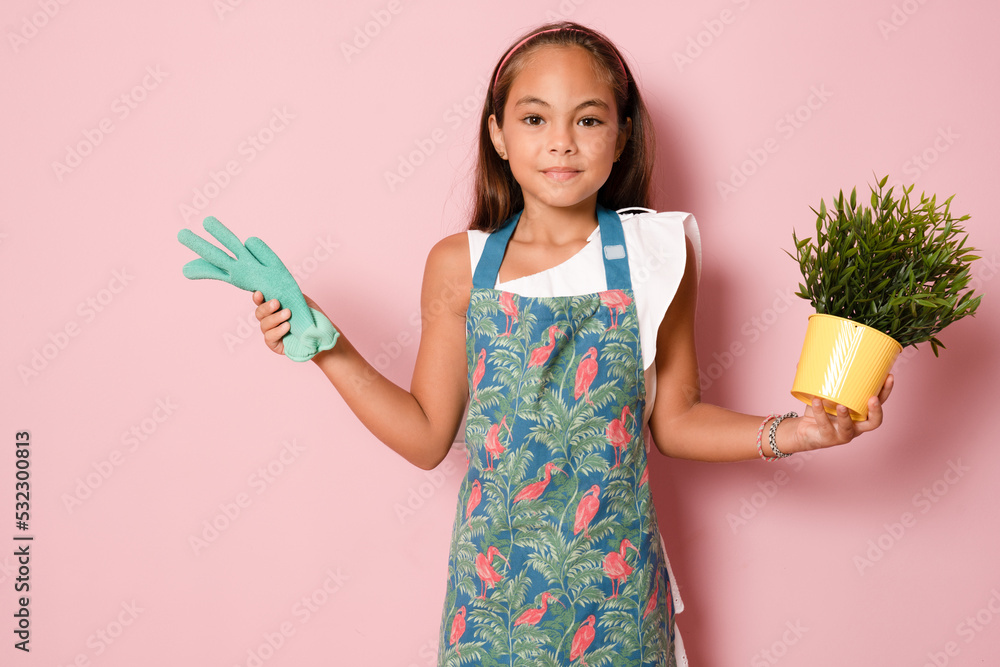 little child girl holding a plant over pink background. little child girl holding a plant over pink background.