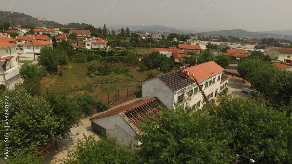 Aerial View of School Roof Change. Roofers Installing a New Roof on an Industrial Building. Old Building Reconstruction. Education Concept. Aerial View of School Roof Change. Roofers Installing a New Roof on an Industrial Building. Old Building Reconstruction. Education Concept.
